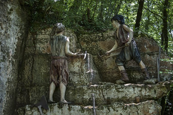 Diorama of medieval quarry workers cutting stones at the Grottes du Roc de Cazelle