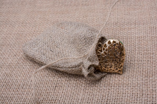 Heart shaped gold color metal object out of sack
