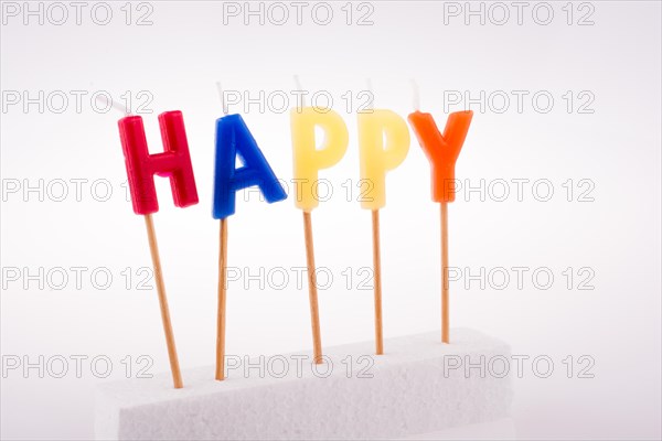Color candles on sticks write the word happy