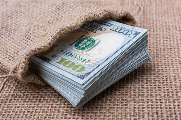Banknote bundle of US dollarin a sack on a canvas
