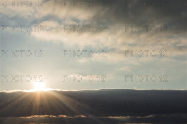 Sun behind beautiful white clouds in midday