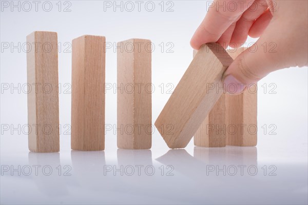 Hand holding wooden domino on a white background
