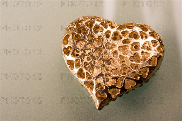 Gold color metal heart shaped object in view