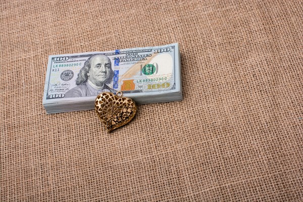 Heart icon bundle of US dollar placed on a linen canvas