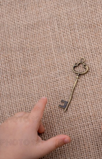 Heart shaped gold color metal object in hand