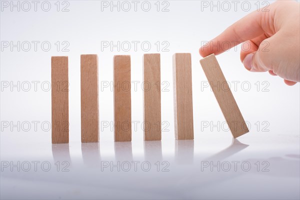Hand holding wooden domino on a white background