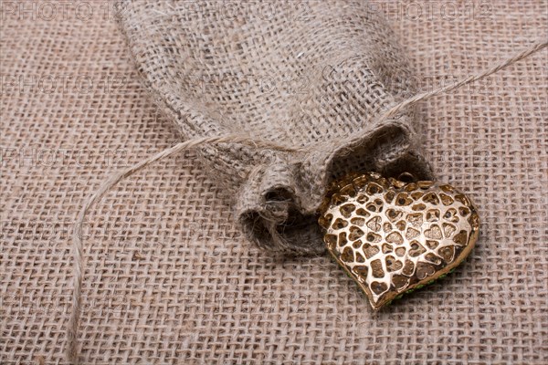 Heart shaped gold color metal object out of sack
