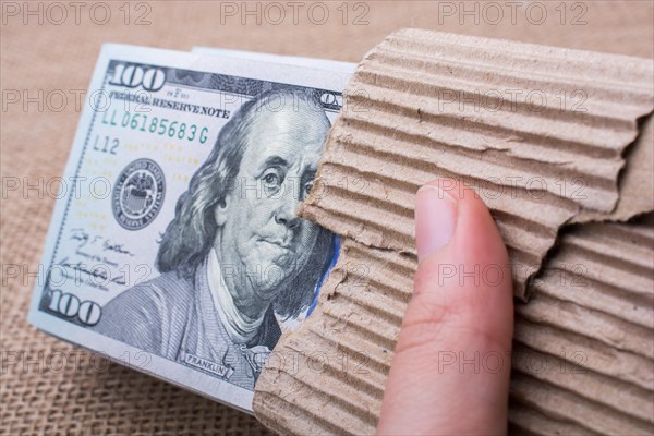 Hand holding banknote bundle of US dollar on a linen canvas background