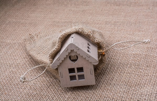 Model house beside a sack on a canvas background