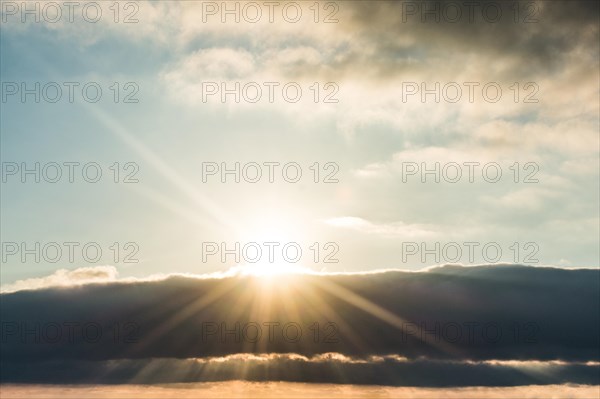 Sun behind beautiful white clouds in midday