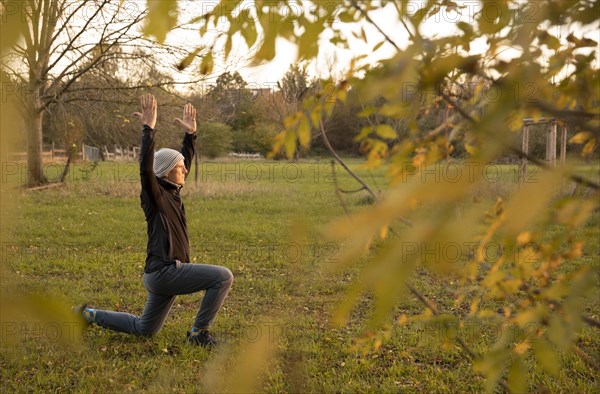 Man stretching in a meadow in autumn. Yoga outdoors.