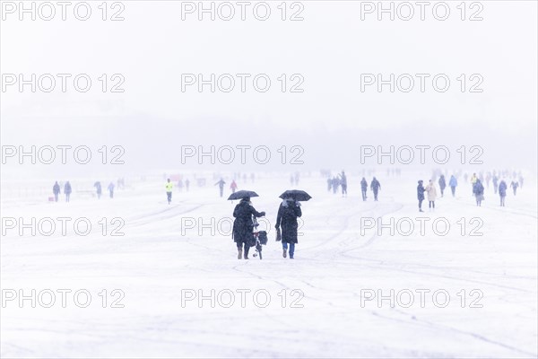 Berliners walk across Tempelhofer Feld in Berlin during snowfall
