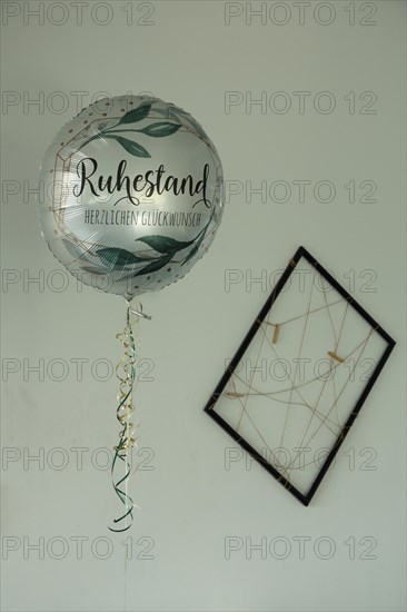 Balloon with inscription retirement and congratulations and picture frame with threads and strings
