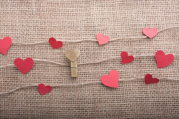 Love concept with heart shaped papers on linen threads