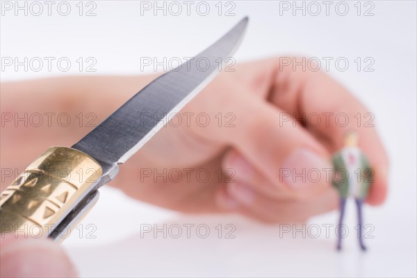 Hand holding a pocket knife near a human figure on a white background