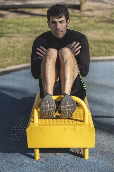 Attractive man doing sit-ups in the park