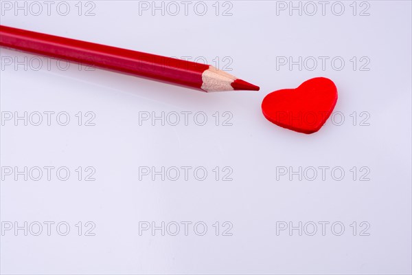Pencil pointing a red heart