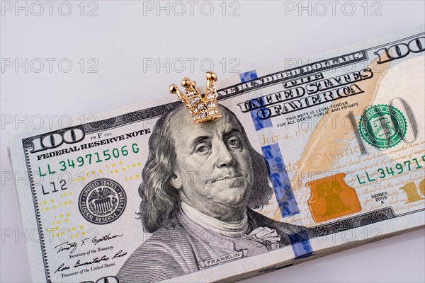 American 100 dollar banknotes and a gold color crown