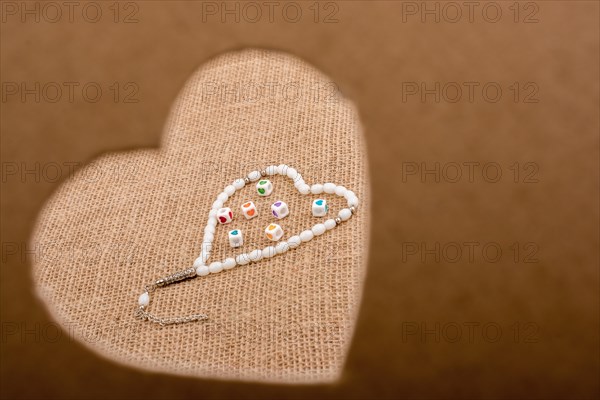 Heart shaped gold color metal object in hand