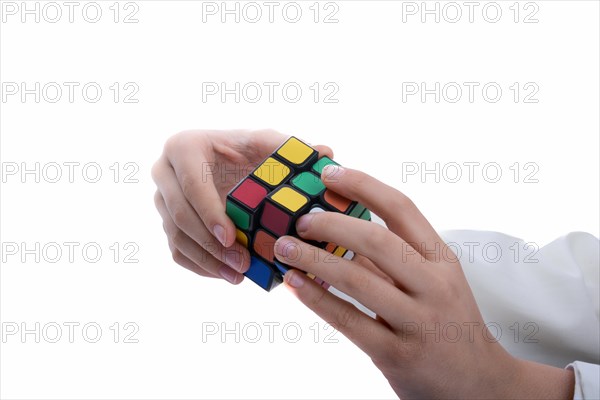 Child holding a Rubik's cube in hand on a white background