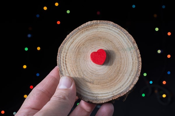 Heart shaped objectin hand on bokeh light background
