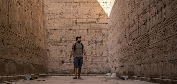 A young tourist visiting the beautiful temple of Edfu in the city of Edfu