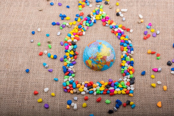 Globe in the house form shaped by colorful pebbles