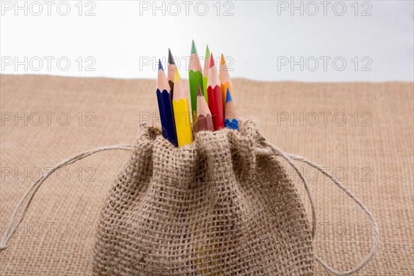 Color Pencils in a linen sack on canvas