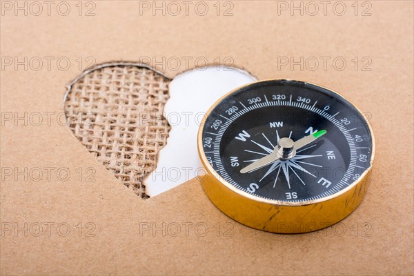Heart shaped gold color metal object in hand