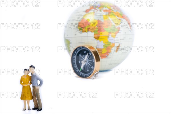 A couple by the side of a globe with a compass on isolated white background