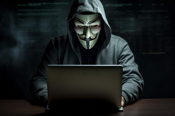 Hacker with Anonymous mask on notebook