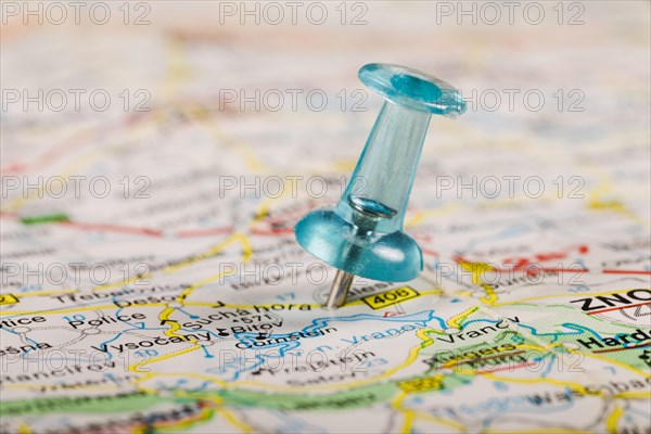 Turquoise colored pushpin stucked world map