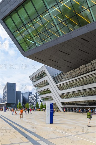 Students in front of modern building on the campus of the University of Economics WU