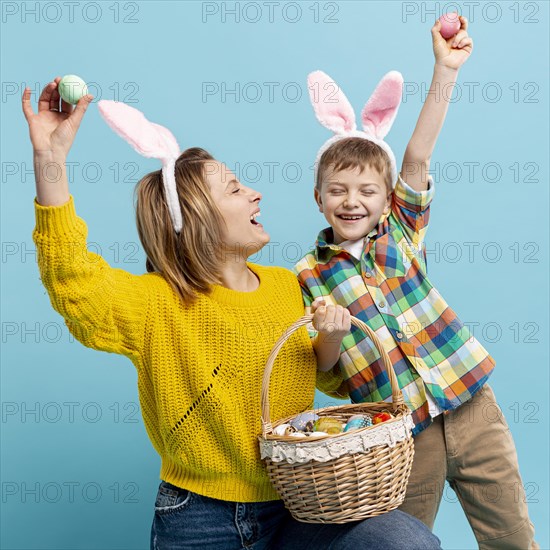 Playful mother son showing painted eggs