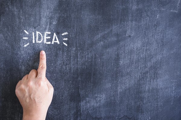 Person pointing finger idea text written chalk blackboard