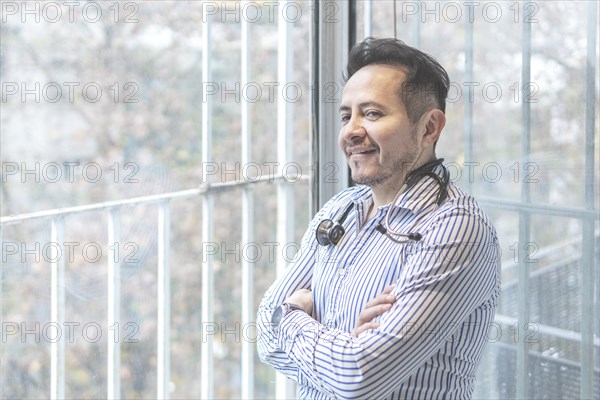 Portrait of latin doctor posing in his office