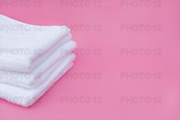 Stack white towels pink background