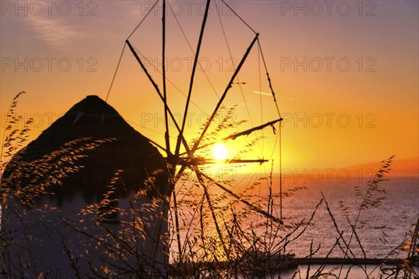 Silhouette of famous traditional Greek windmill against colorful sunset sky