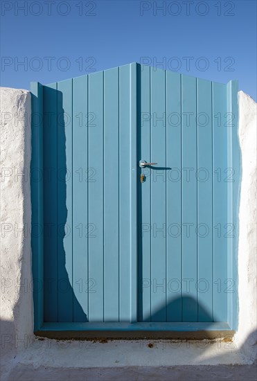 Blue wooden door with clear sky in the backgroud. Ia