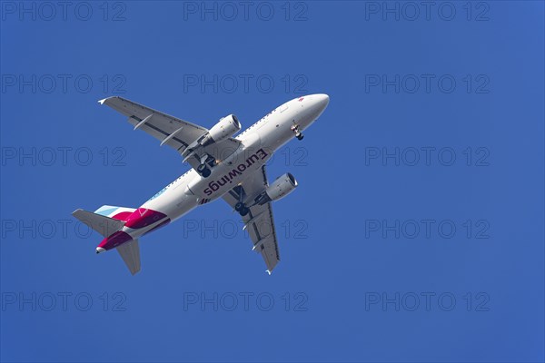 Passenger aircraft of the airline Eurowings in flight with extended landing gear
