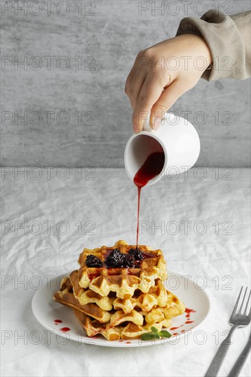 Close up hand pouring syrup