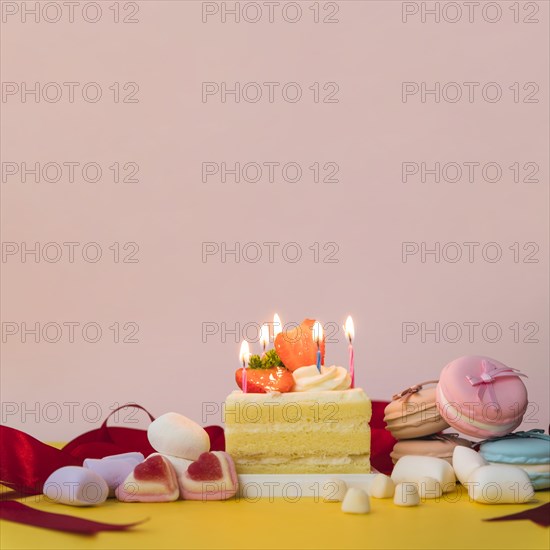 Decorated cakes with candies marshmallow macarons yellow desk