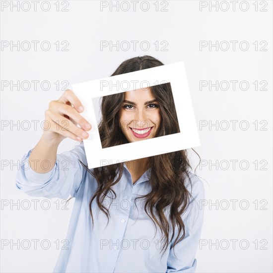 Joyful woman holding frame front face