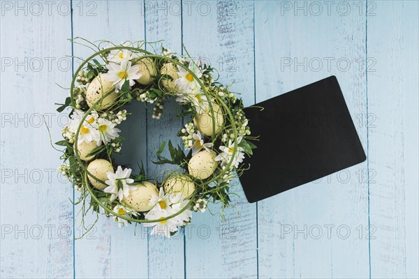 Easter wreath lying near black paper