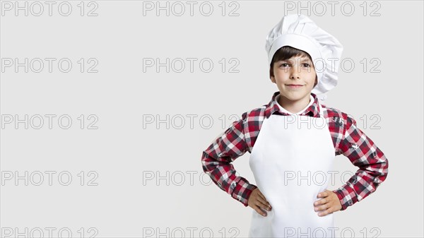 Cute young boy posing as chef