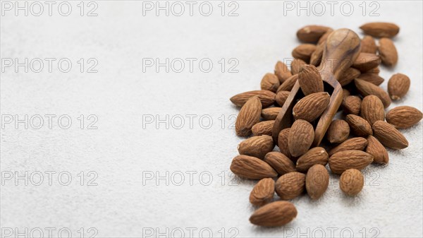 Organic almond nuts wooden spoon copy space