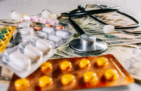 High cost of medical health with stethoscope. Medical stethoscope with medicaments on money