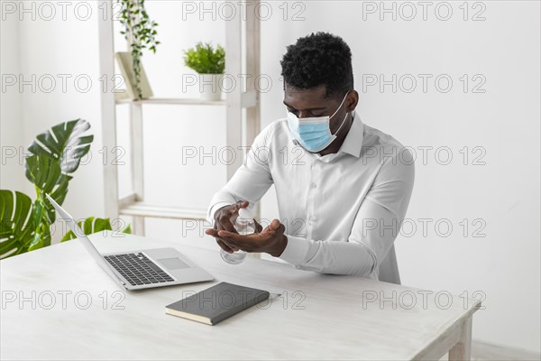 African american man wearing mask cleaning his hands