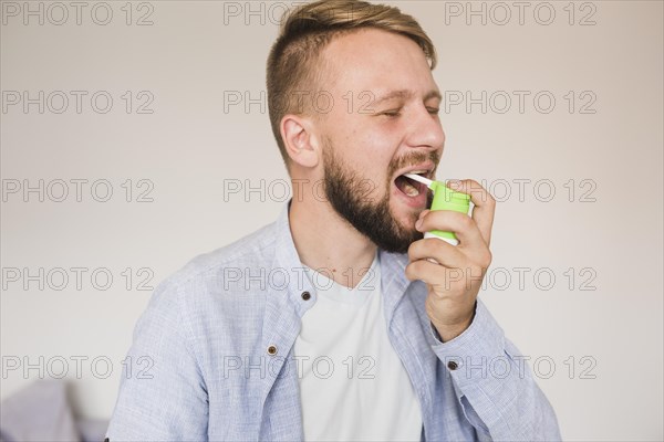 Male using spray sore throat