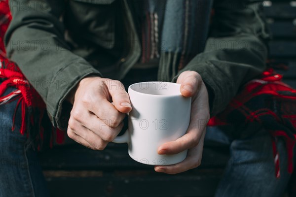 Close up person holding up white mug